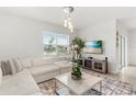 Bright living room with neutral decor, a comfortable sectional sofa, modern lighting, and large windows at 8246 Dolphin Bluff Blvd, Wesley Chapel, FL 33545