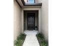 Welcoming front entryway with a black door, neutral tones, and decorative plants for inviting curb appeal at 11826 Sky Acres Ter, Bradenton, FL 34211