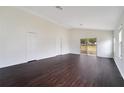 Spacious living room with dark wood-look flooring and sliding glass doors to the backyard at 13202 Golf Ridge Pl, Hudson, FL 34669