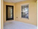Inviting front porch with tiled flooring, decorative front door, and natural light from a window at 19648 Timberbluff Dr, Land O Lakes, FL 34638