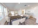 Bright and airy living area featuring an open floor plan, kitchen island with seating, and ample natural light from large windows at 14699 Italy Ave, Dade City, FL 33523