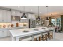 Modern kitchen with a large island, stainless steel appliances, and stylish pendant lighting at 1785 Trailhead Ln, Zephyrhills, FL 33541