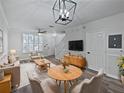 Bright living room featuring modern light fixture, stylish decor, and ample seating at 6122 Osprey Lake Cir, Riverview, FL 33578