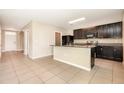 Open kitchen with dark cabinetry, granite countertops, and stainless steel appliances at 11807 Myrtle Rock Dr, Riverview, FL 33578