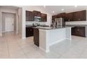 Modern kitchen featuring stainless steel appliances, dark wood cabinets, and granite countertops at 13581 Willow Bluestar Loop, Riverview, FL 33579