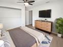 A staged bedroom featuring modern furniture and a large TV at 1404 Rosewood Ave, Dunedin, FL 34698