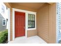 A close-up of the home's inviting red front door with white trim and adjacent window at 5710 Colony Glen Rd, Lithia, FL 33547