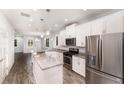 Open-concept kitchen boasts stainless steel appliances, granite countertops, and wood-look flooring at 5710 Colony Glen Rd, Lithia, FL 33547