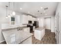 Bright kitchen featuring white cabinets, stainless steel appliances, granite countertops, and pendant lighting at 5710 Colony Glen Rd, Lithia, FL 33547
