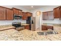 Modern kitchen featuring granite countertops, stainless steel appliances, and dark wood cabinets at 13417 Lake Monroe Pl, Riverview, FL 33579