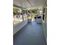 View of a screened in front porch with a freshly painted floor and view of the front yard at 3615 E Grove St, Tampa, FL 33610
