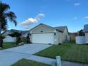 Exterior side view of home with well-manicured lawn and landscaping, and two-car garage at 1210 Etchfield Cir, Brandon, FL 33511