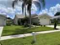 Exterior front view of home with manicured lawn, landscaping, and a two-car garage at 1210 Etchfield Cir, Brandon, FL 33511