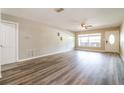 Bright and airy living room featuring laminate floors, ceiling fan, and a large window at 1453 Thames Ln, Clearwater, FL 33755