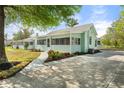 Charming home featuring a cozy screened porch, complemented by a spacious driveway and lush landscaping at 514 Fitzhugh Ave, Punta Gorda, FL 33950