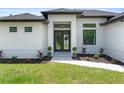 Close up of the front door with decorative landscaping and a stone paver walkway at 2805 Anniston Rd, North Port, FL 34288