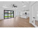 A spacious living room with modern ceiling fan and an island kitchen with white cabinets at 2805 Anniston Rd, North Port, FL 34288