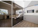 Outdoor patio with tiled floor, fire pit, kitchenette, and partial screens at 235 Cocoanut Ave # 129E, Sarasota, FL 34236