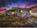 A beautiful single-story home with an attached garage and an arched entryway, enhanced by a colorful sunset at 4601 Copper Ln, Plant City, FL 33566