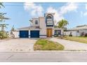 Two-story home with blue garage doors, concrete driveway, and distinctive architecture at 11120 5Th E St, Treasure Island, FL 33706