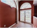 Hallway with vaulted ceilings with arched windows, and double doors that lead to outdoor scenery at 11120 5Th E St, Treasure Island, FL 33706
