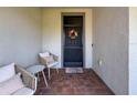 Cozy front porch with comfortable seating, a 'Home Sweet Home' welcome mat, and a decorative wreath at 18743 Coastal Shore Ter, Land O Lakes, FL 34638