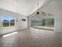 Bright living room featuring tile floors, high ceilings, and access to outdoor patio at 4249 Hawksley Pl, Wesley Chapel, FL 33545
