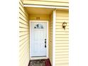 Close-up of the front door with white trim and a decorative light fixture at 22620 Gage Loop # 25, Land O Lakes, FL 34639