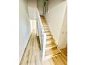 Hallway view showcasing wood-look flooring and white staircase at 22620 Gage Loop # 25, Land O Lakes, FL 34639