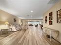 Bright open-plan living room boasts wood-look tile flooring, neutral walls, and views to the dining and seating areas at 2436 Deer Trail Ln, Spring Hill, FL 34606