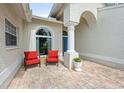 Inviting front porch with brick pavers, seating area, and bright blue front door at 2444 Grandfather Mtn, Spring Hill, FL 34606