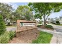 Green Meadow Village brick community sign amid lush greenery, creating a welcoming entrance at 2444 Grandfather Mtn, Spring Hill, FL 34606