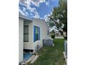 Side view of home featuring neutral siding, blue shutters, A/C unit and well-maintained lawn at 34315 Timberland Blvd, Wesley Chapel, FL 33543