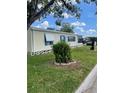 A cozy single-story home with a well-maintained lawn, complemented by bright blue window shutters and awning at 34315 Timberland Blvd, Wesley Chapel, FL 33543