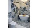 Luxurious bathroom featuring a soaking tub, rainfall shower, and stylish blue and gold marble-look tile at 23 Golfview Rd, Rotonda West, FL 33947