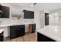 Modern kitchen featuring sleek black cabinets, white countertops, and stylish backsplash, next to the entry door at 3400 Dawson Ln, Punta Gorda, FL 33950