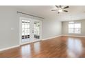 Bright living room featuring wood floors, modern ceiling fan and french doors with backyard view at 13516 Copper Head Dr, Riverview, FL 33569