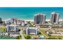 Aerial view of beachfront condos with pools, tennis courts, and easy access to the beach and Intracoastal Waterway at 1581 Gulf Blvd # 102N, Clearwater Beach, FL 33767