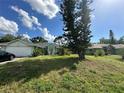 Charming single-story home featuring a well-maintained lawn, landscaping, and a driveway at 21285 Peachland Blvd, Port Charlotte, FL 33954