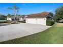 Long driveway leads to a three car garage on this single-story home, showcasing lush landscaping and mature trees at 12402 Creek Edge Dr, Riverview, FL 33579