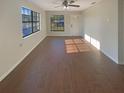 Open-concept living area showcasing hardwood floors and ample natural light from large windows at 701 71St N Ave, St Petersburg, FL 33702