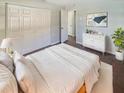 Bright main bedroom featuring neutral walls, hardwood floors, closet, dresser, and comfortable bed at 701 71St N Ave, St Petersburg, FL 33702