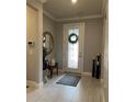 Inviting foyer with tiled floor, bench seating, decorative wreath on the front door and elegant decor at 1427 Hyssop Loop, North Port, FL 34289