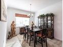 Formal dining room with dark wood table and chairs, hardwood floors, and elegant china cabinet at 25301 Longmeadow Dr, Punta Gorda, FL 33955