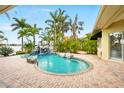 Beautiful pool featuring a rock waterfall, surrounding lush tropical foliage, and a view of the water at 5405 Merritt Island Dr, Apollo Beach, FL 33572