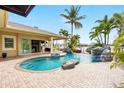 Backyard pool with a rock waterfall feature, brick patio, covered porch, and stunning views at 5405 Merritt Island Dr, Apollo Beach, FL 33572