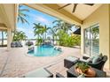 Inviting pool area with palm trees, a waterfall feature, and comfortable outdoor seating overlooking the water at 5405 Merritt Island Dr, Apollo Beach, FL 33572