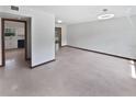 Spacious living room featuring pristine hardwood floors and a glimpse into the adjacent kitchen at 11114 N 21St St, Tampa, FL 33612