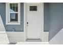 A close up of the front door with a glass window, brick details, and a doorbell at 1869 Brekey Way, Zephyrhills, FL 33541