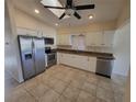 Modern kitchen with stainless steel appliances, ample counter space, and white cabinetry at 89 Mark Twain Ln, Rotonda West, FL 33947